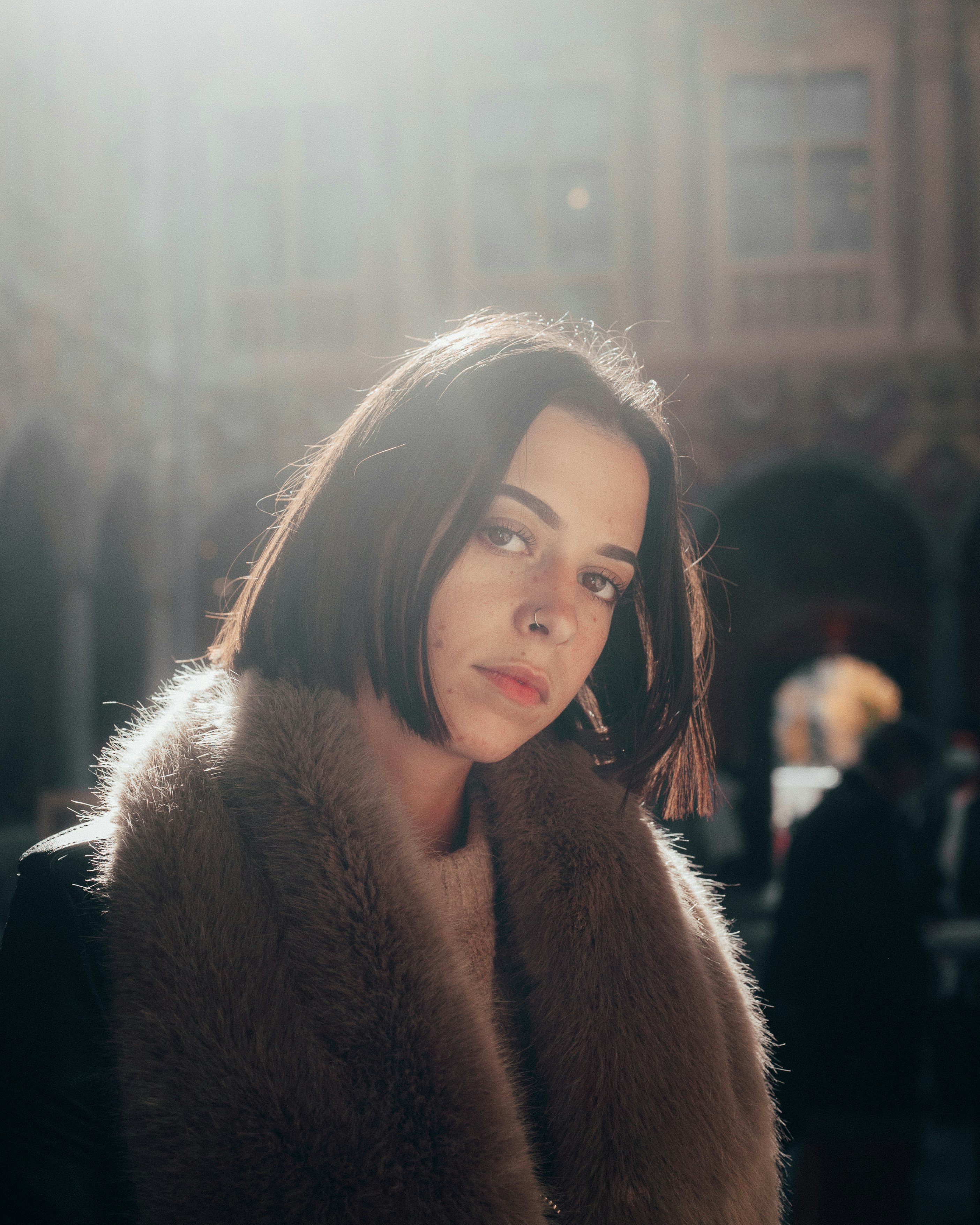 woman in brown fur coat standing near people during daytime